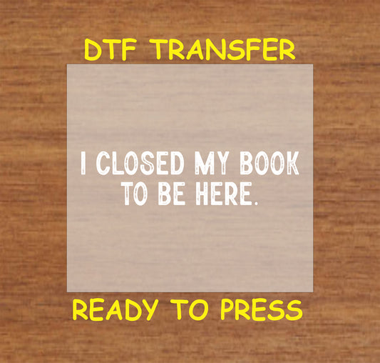 White text reading "I Closed My Book To Be Here" on a neutral background.