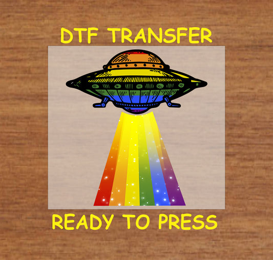 UFO Pride DTF transfer with a spaceship beaming a rainbow-colored light.