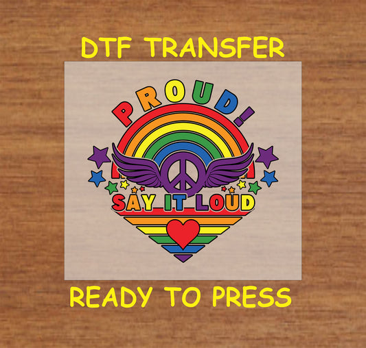 "Proud Say It Loud" rainbow heart with peace sign, wings, and stars in bright colors, perfect for custom LGBTQ+ apparel.