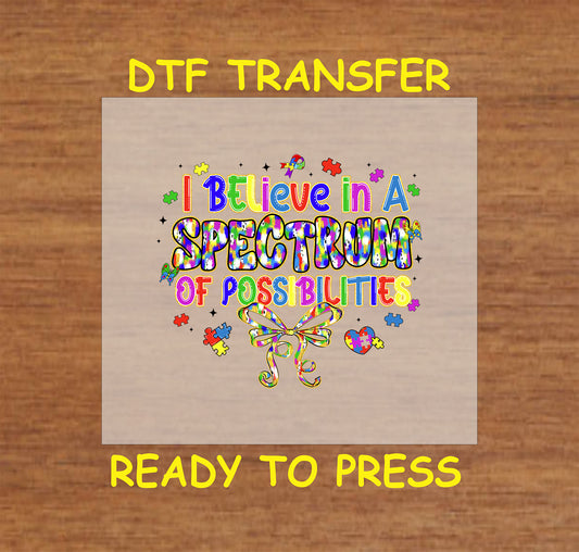 Colorful “I Believe in a Spectrum of Possibilities” text with puzzle pieces and bow.
