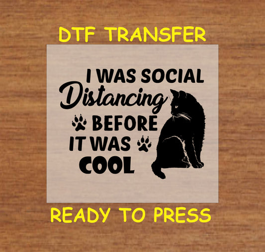 DTF transfer of black cat with text “I Was Social Distancing Before It Was Cool” and paw prints.