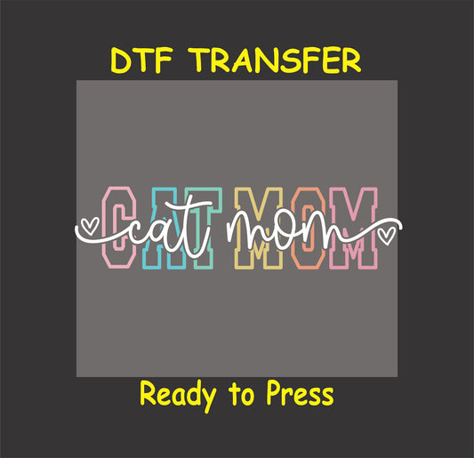 DTF transfer with pastel block letters spelling "Cat Mom" overlaid by cursive text with heart accents.