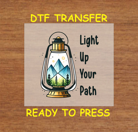 Light Up Your Path DTF transfer with lantern holding mountain and pine tree landscape.