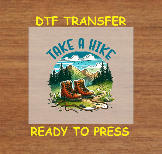 Hiking boots on a trail with trees and mountains under a blue sky, ready-to-press DTF transfer.