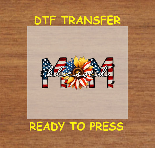 DTF transfer with patriotic MOM text, sunflower center, and blessed script overlay.