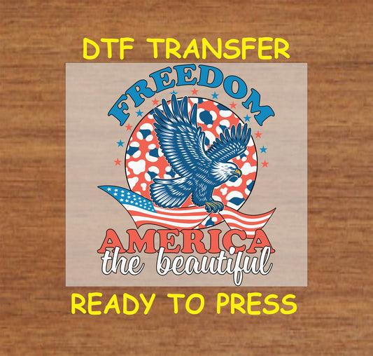 Flying eagle over flag with Freedom America the Beautiful text in red white and blue.