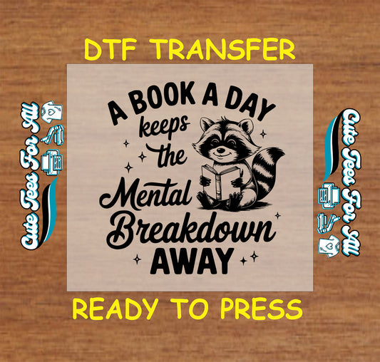 Black and white DTF transfer with raccoon holding book and funny reading quote.