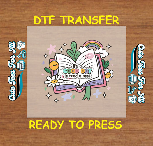 Colorful DTF transfer with open book, rainbow, daisies, and the phrase "It’s a Good Day to Read a Book"