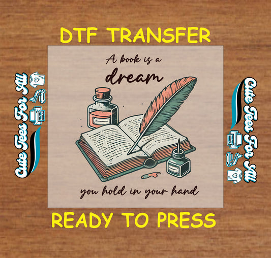DTF transfer with an open book, quill pen, ink bottles, and the quote “A book is a dream”
