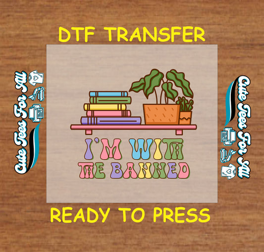 DTF transfer with books, plant, and phrase “I'm With the Banned” in colorful retro letters.