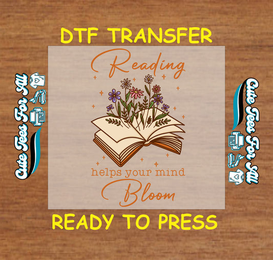 DTF transfer with open book and blooming wildflowers above the phrase “Reading helps your mind bloom”