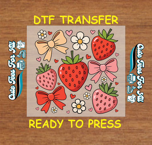 DTF transfer with strawberries, bows, hearts, and daisy flowers on a tan background.