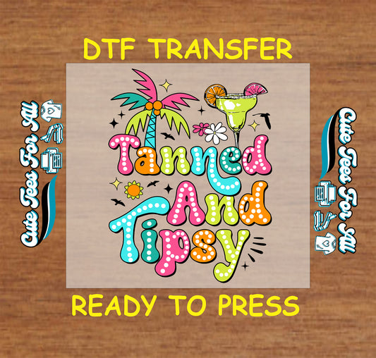 DTF transfer with colorful Tanned and Tipsy text, palm tree, margarita, and flowers.