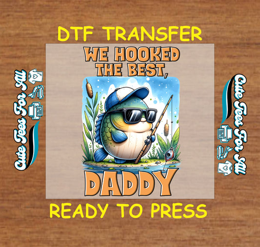 DTF transfer with cartoon fish in cap and sunglasses, holding a fishing pole, with “We Hooked the Best, Daddy” text.