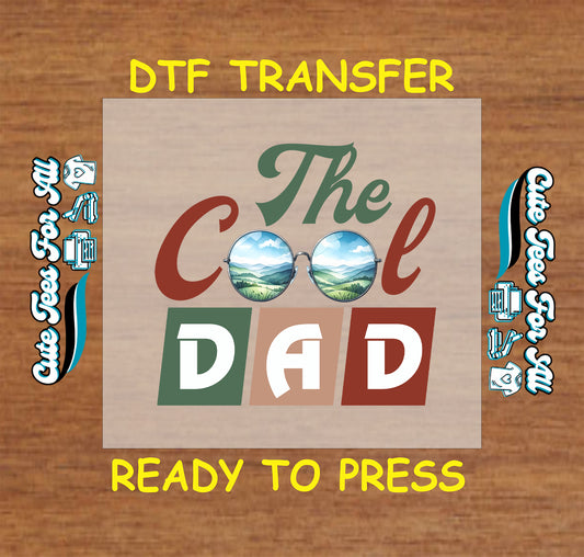 DTF transfer with “The Cool Dad” text and sunglasses showing landscape reflection.