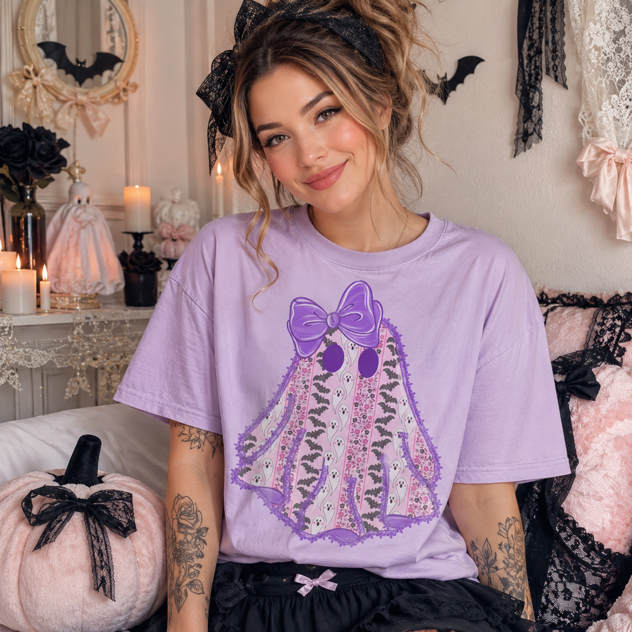 A woman wearing a light purple Halloween-themed t-shirt with a ghost graphic, posed in a cozy, decorated room with gothic decor.