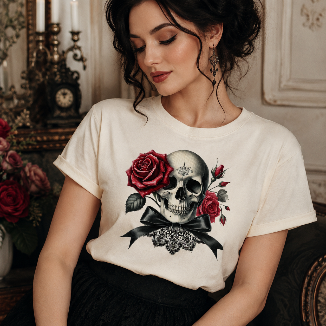 A woman wearing a cream-colored t-shirt with a graphic print of a skull, red roses, and a black bow. The setting is a dimly lit, elegant interior with vintage decor.