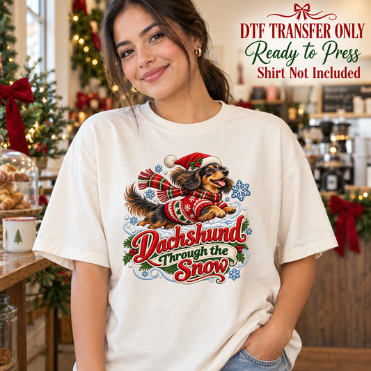 Christmas Dachshund Through the Snow design shown on a cream shirt worn by a model; DTF transfer only, shirt not included.