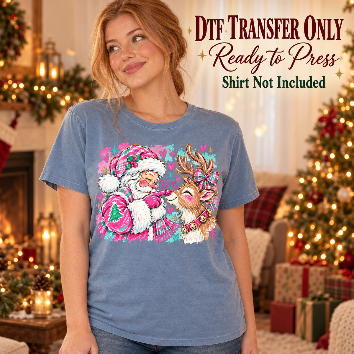 Christmas Pink Santa and Reindeer design shown on a blue shirt worn by a model; DTF transfer only, shirt not included.