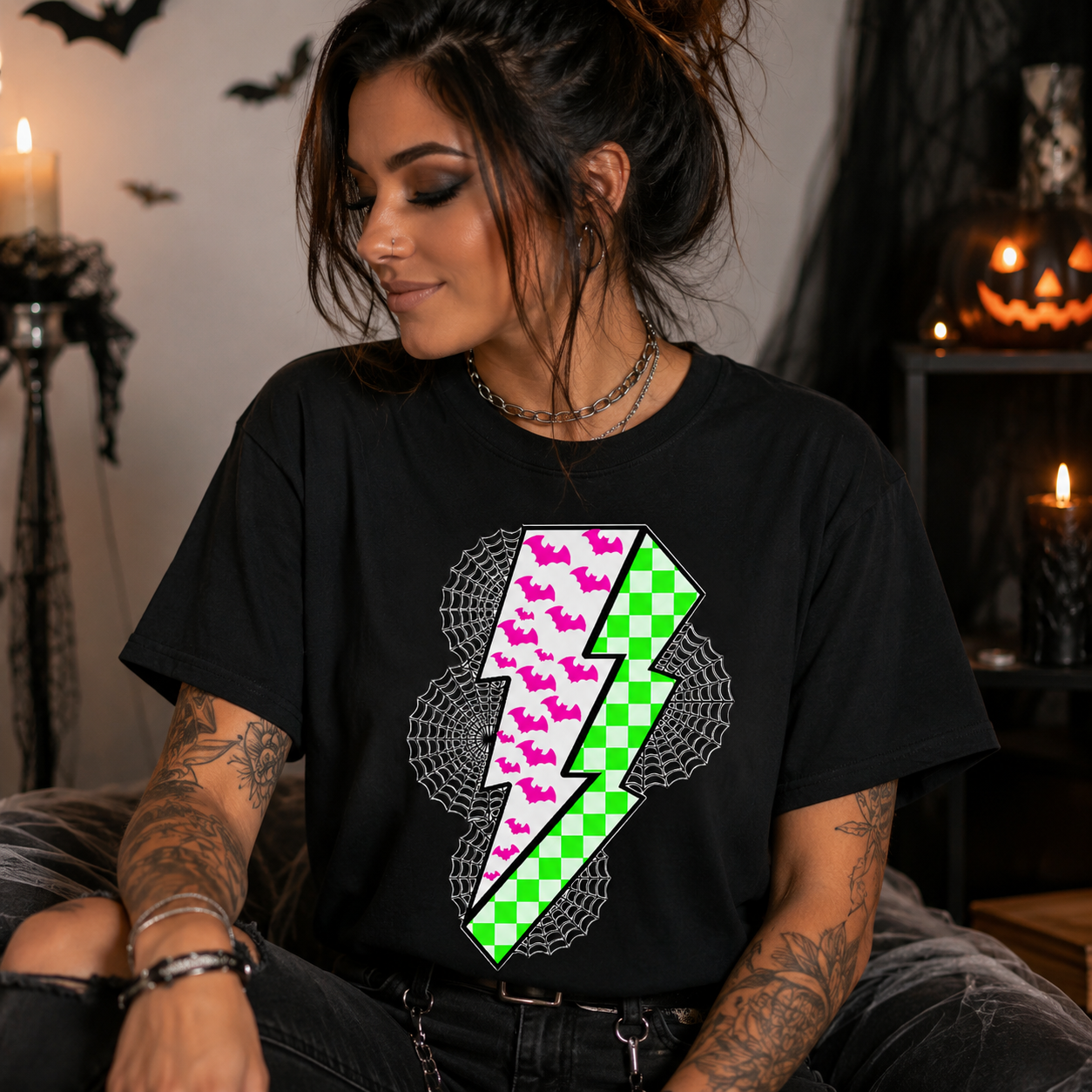 A woman wearing a black t-shirt with a graphic of a split lightning bolt, one side patterned with pink butterflies and the other with a green and white checkered pattern, set against a dark, spooky Halloween-themed background.