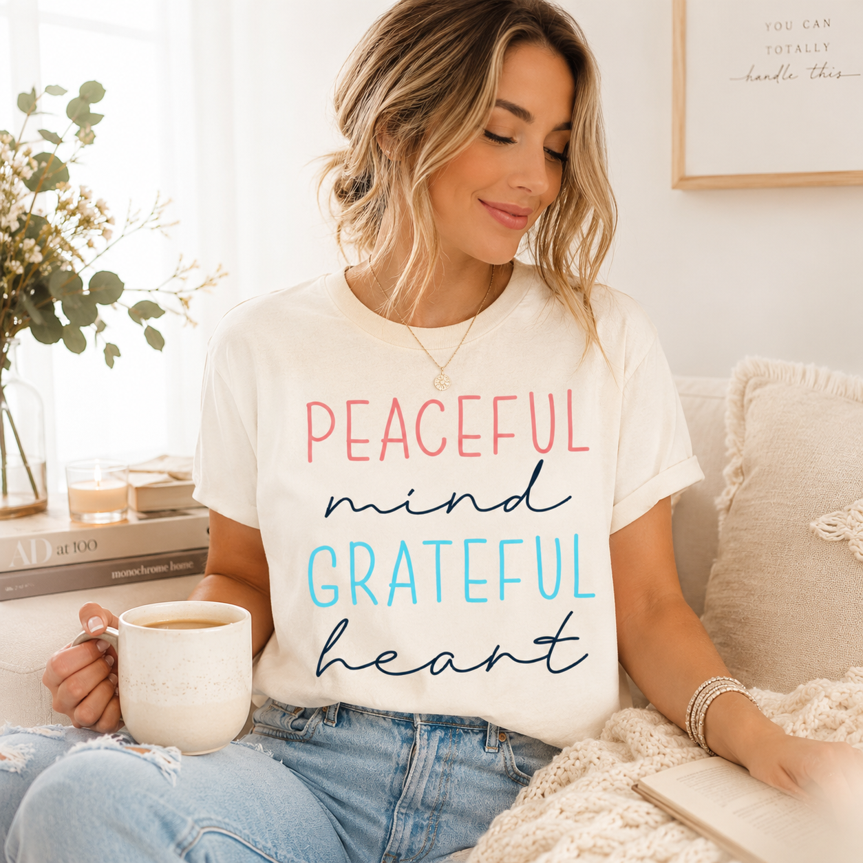 Cream shirt mockup featuring an inspirational ready to press dtf transfer with the phrase Peaceful mind Grateful heart in soft pink, blue, and navy lettering.